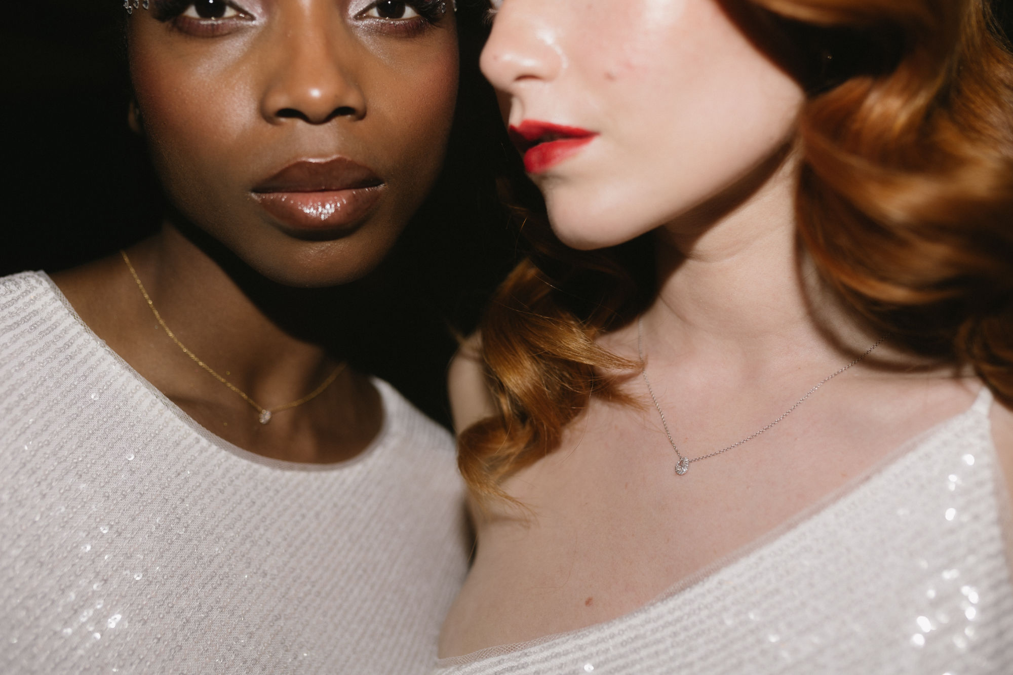 Close-up of two brides, focusing on their diamond necklaces.