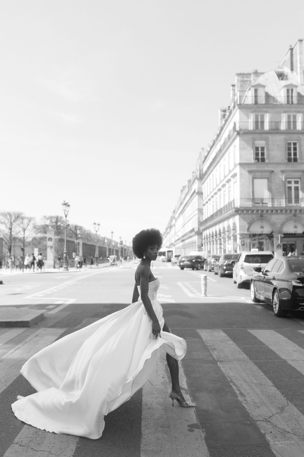 Bride crossing Paris street, dress billowing in wind.