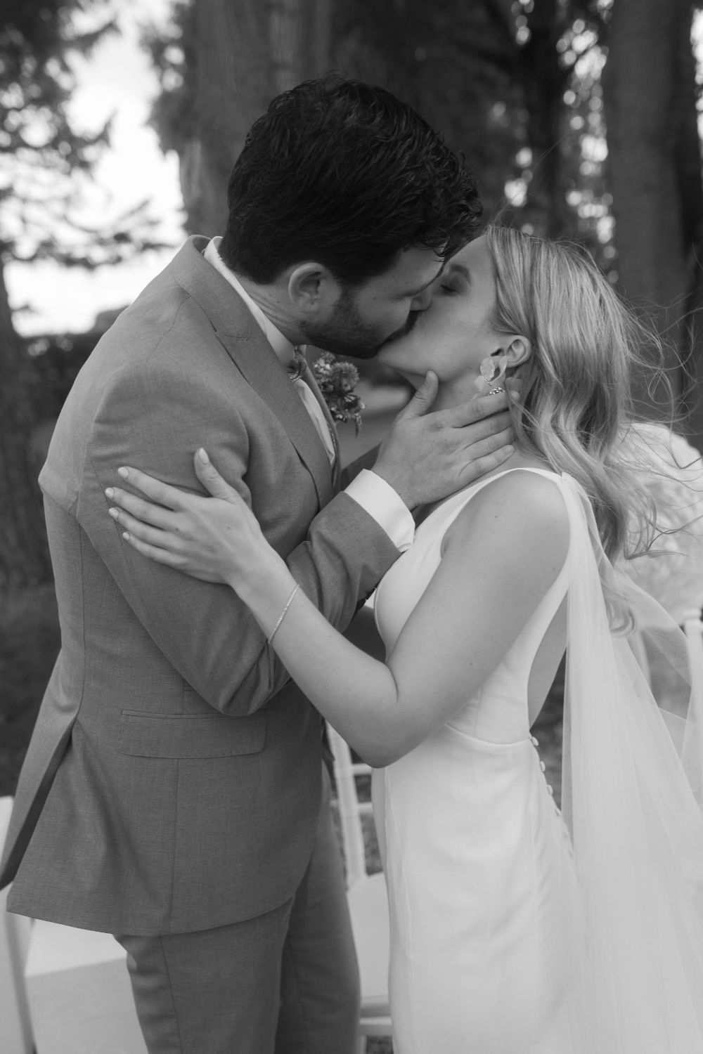 Bride and groom share a kiss during wedding ceremony.