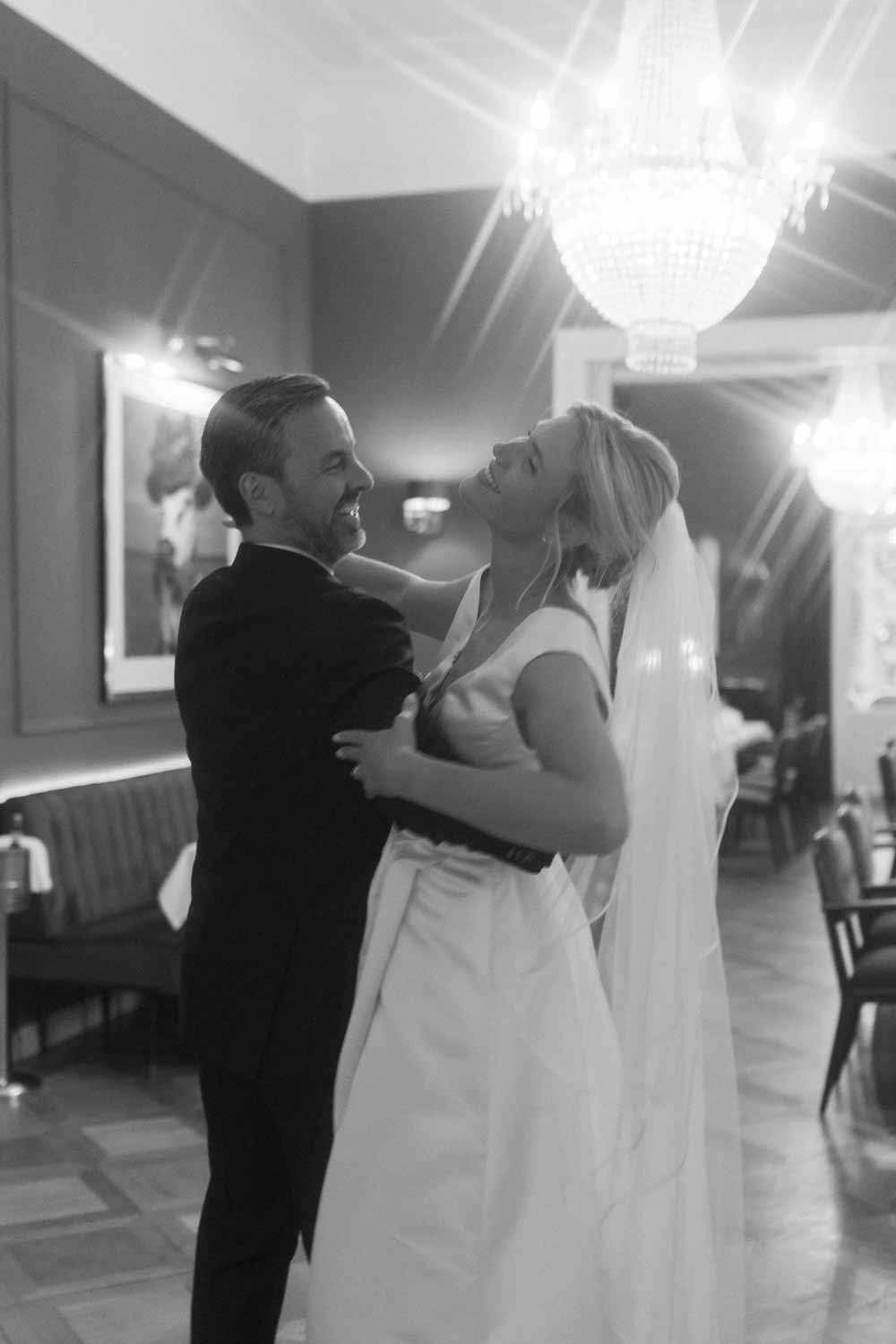 Joyful bride and groom share a dance during dinner.