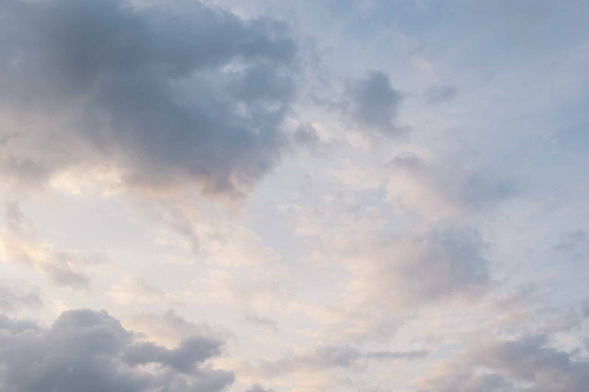 Photo of a beautiful sky with blue, lavender, and light purple clouds.