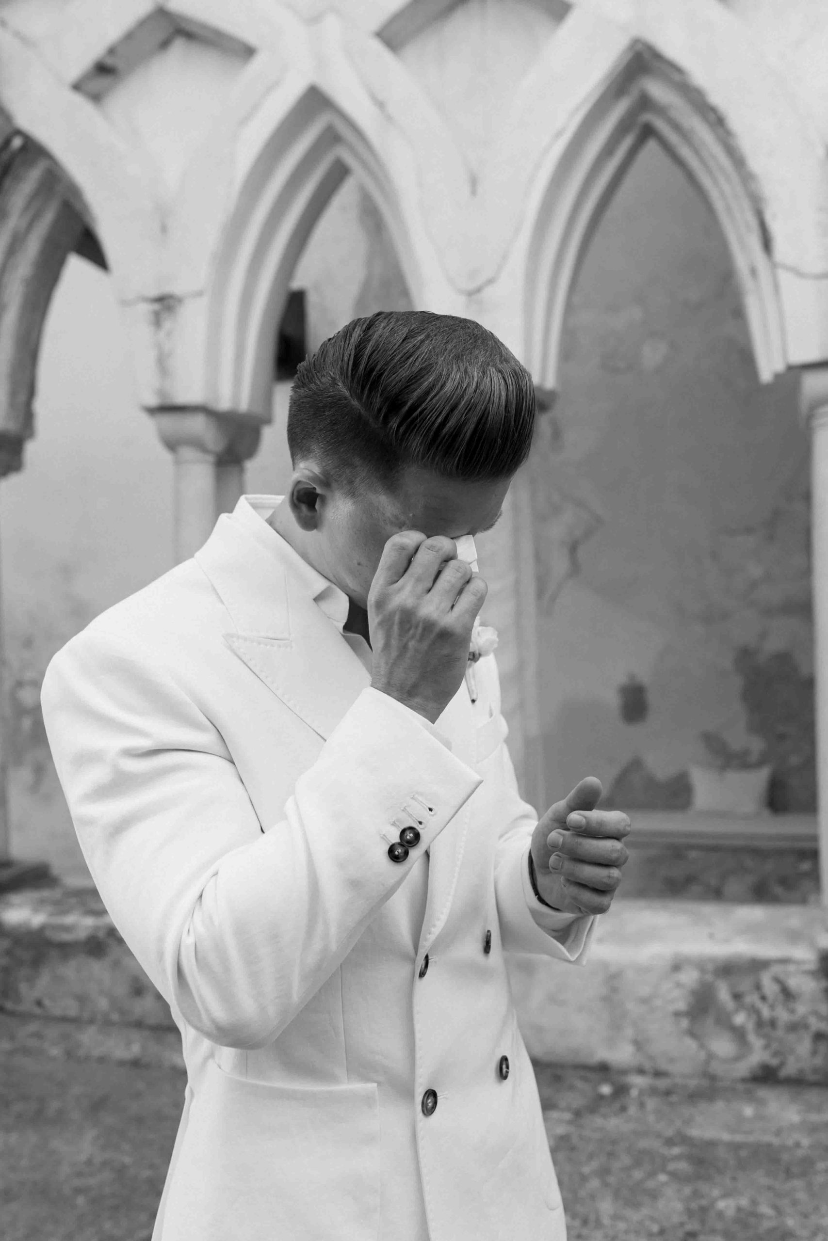 Groom shedding a tear while waiting for the bride